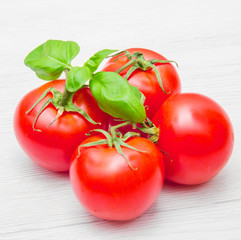 group of fresh resd tomatoes with basil