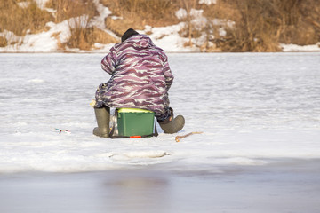  Fishermen on the river catch fish on thin ice in the spring. The danger of falling under the ice. Near the water from melted ice