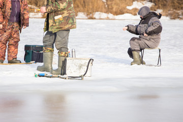  Fishermen on the river catch fish on ice floe in the spring. The danger of falling under the ice. Near the water from melted ice