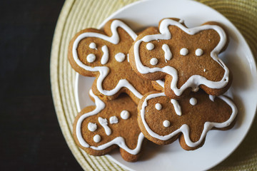 gingerbread men on a white plate on black background