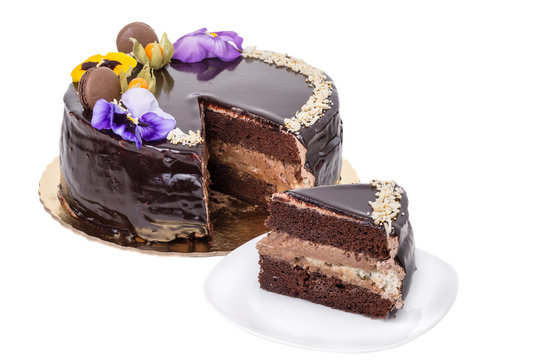 Chocolate cake with flowers, a piece on a plate.