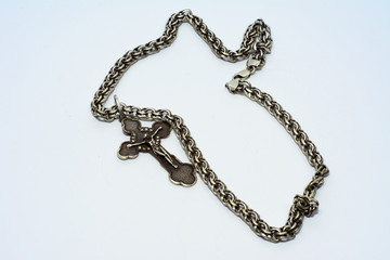 Bracelets, chains and crosses of silver on a white background