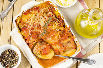 Baked potato gratin with pork meat and tomatoes