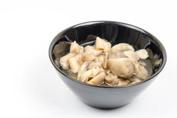 Sliced marinated mushrooms in the bowl isolated over white background