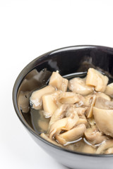 Sliced marinated mushrooms in the bowl isolated over white background
