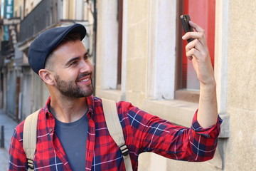 Portrait of a smiling young man about to take a selfie