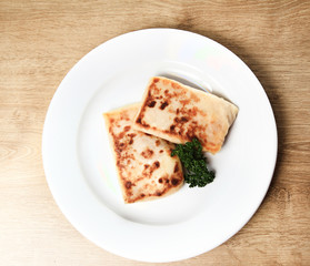 pancakes on white plate on wooden background