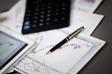 tablet,calculator,pen and financial charts in the workplace businessman