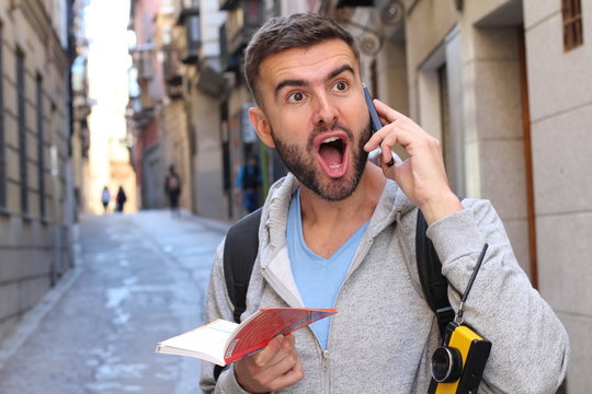 Portrait of a young surprised man talking on the phone