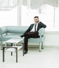 successful businessman sits in the lobby of a modern office and 