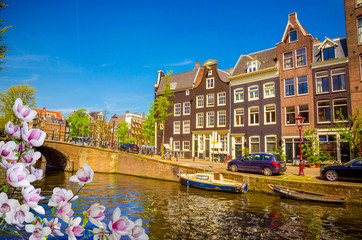 Obraz premium Traditional old buildings and and boats in Amsterdam, Netherlands. Canals of Amsterdam.
