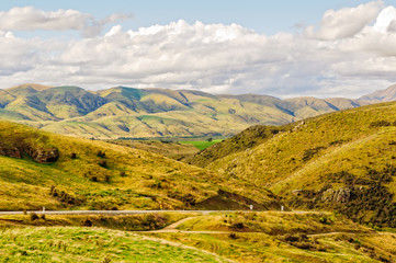 Naklejka premium View of barren hills under clouds from Lindis Pass in Central Otago on the South island of New Zealand
