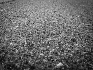 Black abstract natural sandy beach closeup, volcanic seacoast background. Space surface for text