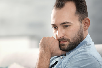 Obraz premium Portrait of handsome depressed man at home