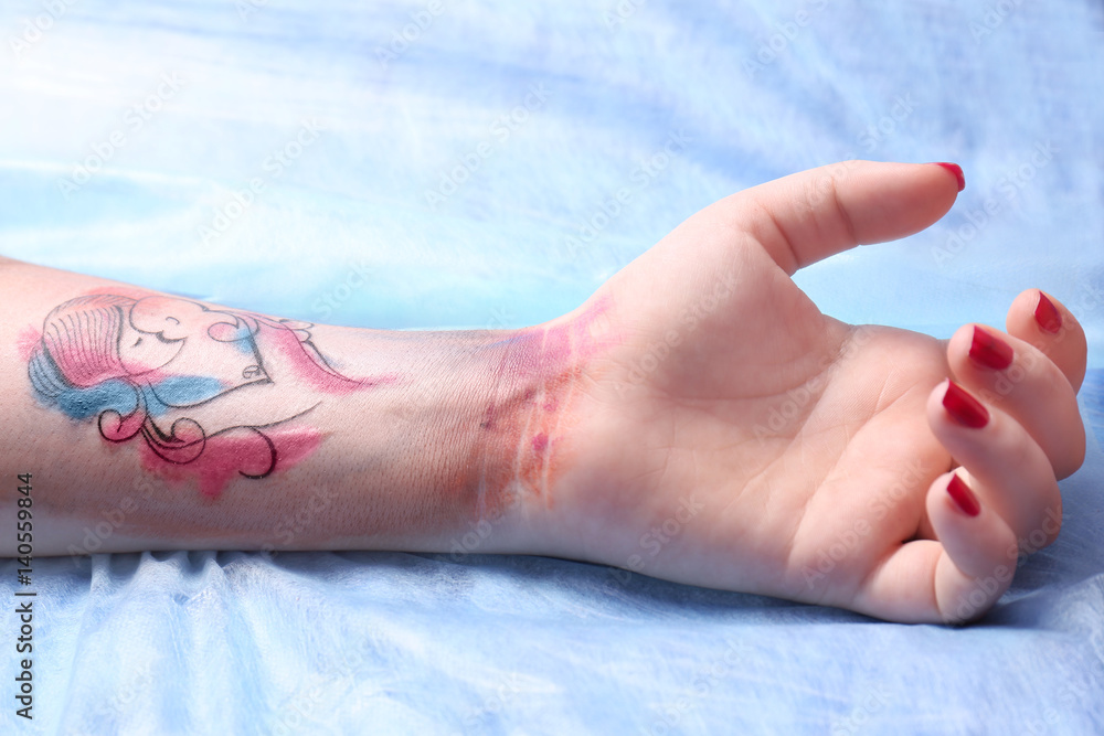 Wall mural Tattoo on female wrist, closeup