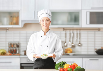 Female chef holding prepared dish in kitchen - Powered by Adobe