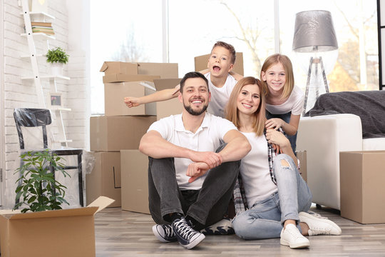 House Move Concept. Happy Family Sitting On The Floor In New Home