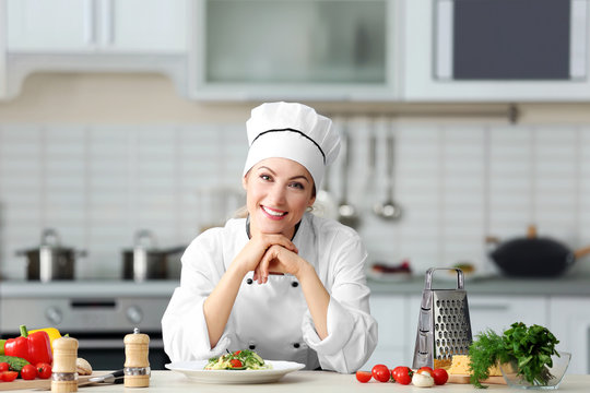 Portrait of young female chef in kitchen
