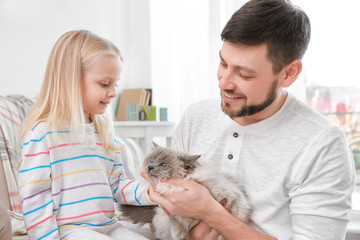 Father and his daughter with cat at home