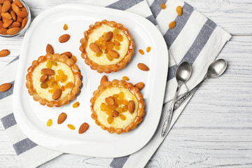 Plate with delicious crispy tarts on wooden background