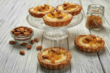Dessert stand with delicious crispy tarts on wooden background