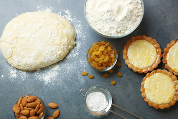 Delicious crispy tarts with almond and raisins on table