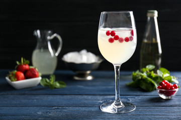 Refreshing cocktail with cranberry on wooden table