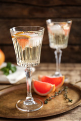Tray with refreshing cocktails and grapefruit on wooden table