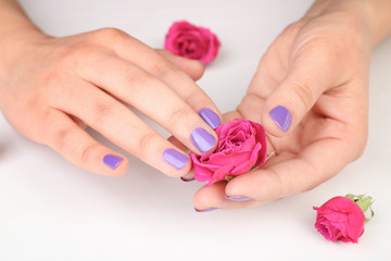 Obraz na płótnie Canvas Nail art concept. Beautiful female hands with manicure and flowers on white background