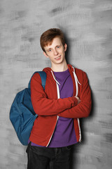 Obraz na płótnie Canvas Teenager with schoolbag near color wall