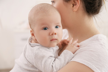 Young woman with cute little baby at home, closeup