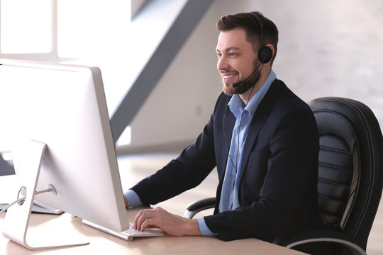 Young man with headset working in office