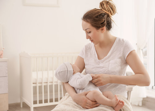 Young woman with cute little baby at home