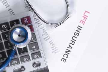 Life insurance concept. Calculator and stethoscope closeup