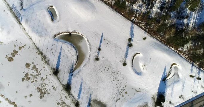 Winter golf course, Cinema 4k aerial rising view above a golf course, near lake Bodom, on a sunny and snowy winter day, in Espoo, Finland