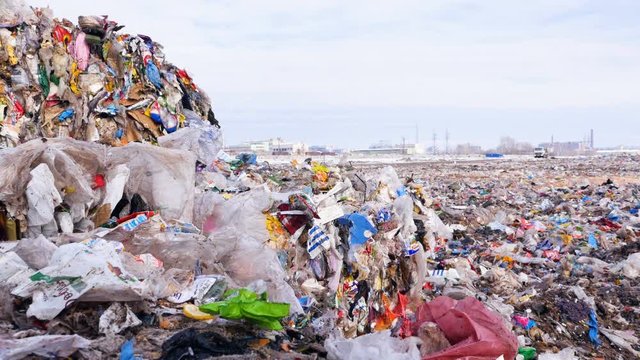 Big piles of garbage. Plastic, packages, polyethylene in a garbage dump. Dolly shot. 4K