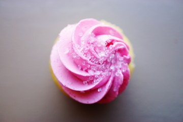 Mini cupcake with pink frosting and sanding sugar on top