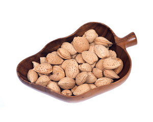Raw almonds in shell in wooden vintage bowl isolated on white background