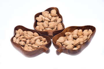 Raw almonds in shell in wooden vintage bowl isolated on white background