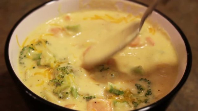Spoon stirs broccoli cheddar soup