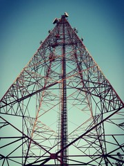 Telecommunication tower in beautiful clear sky. Picture in dark and retro style.