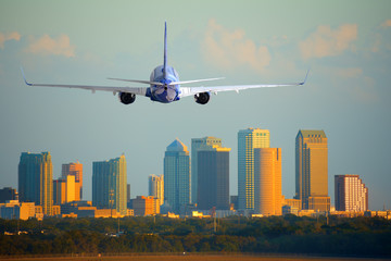 Passenger jet airliner plane arriving or departing Tampa International Airport in Florida at sunset or sunrise - 140574056
