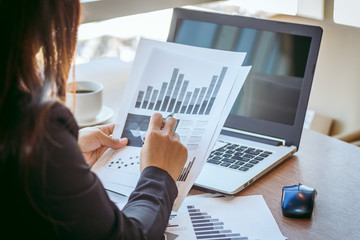 Close Up businessmen working at a coffee shop with a document with a smartphone and a laptop computer.
