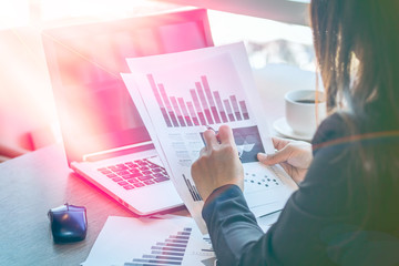 Close Up businessmen working at a coffee shop with a document with a smartphone and a laptop computer.