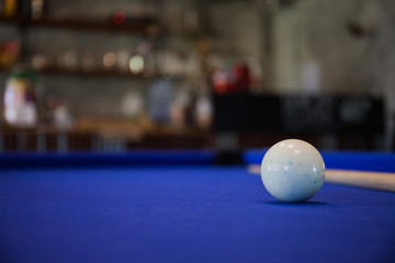 white Billiard ball on blue pool table