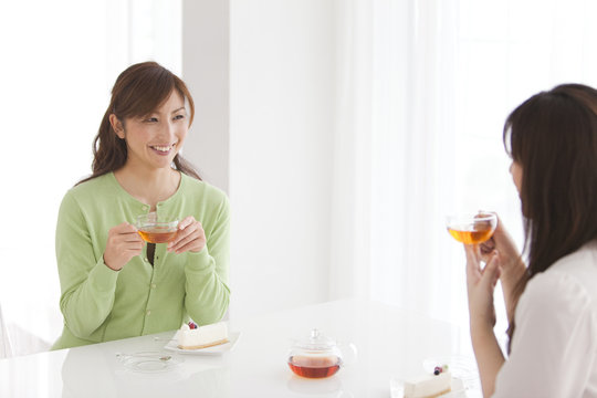Two Mid Adult Women Having Tea and Cake