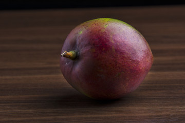 Mango on the wooden table, dark background