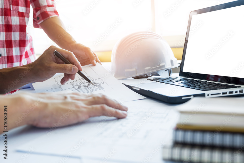 Aufkleber architects engineer discussing at the table with blueprint - closeup on hands and project print