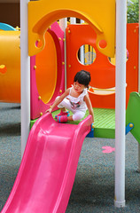 asian baby child girl playing on playground, slider