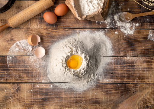 Egg yolk in flour on a wooden background